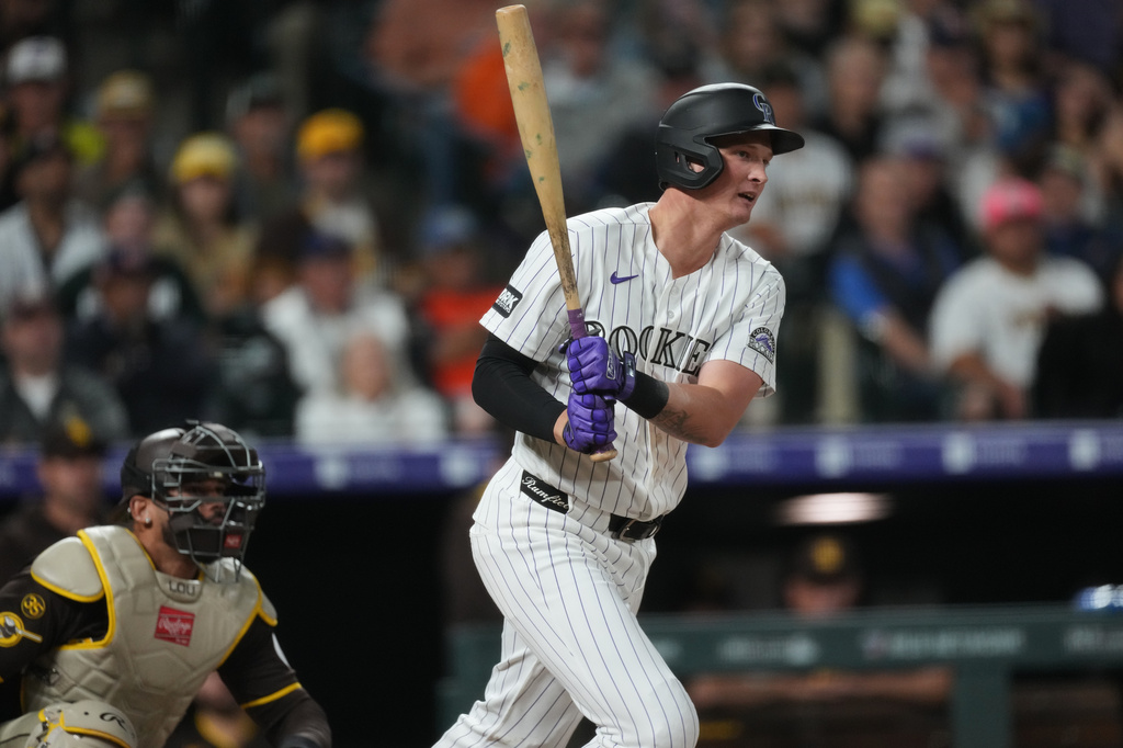 Colorado Rockies' TJ Rumfield follows the flight of his RBI single off San Diego Padres relief pitcher Kyle Hart in the fourth inning of a baseball game Wednesday, April 22, 2026, in Denver. (AP Photo/David Zalubowski)