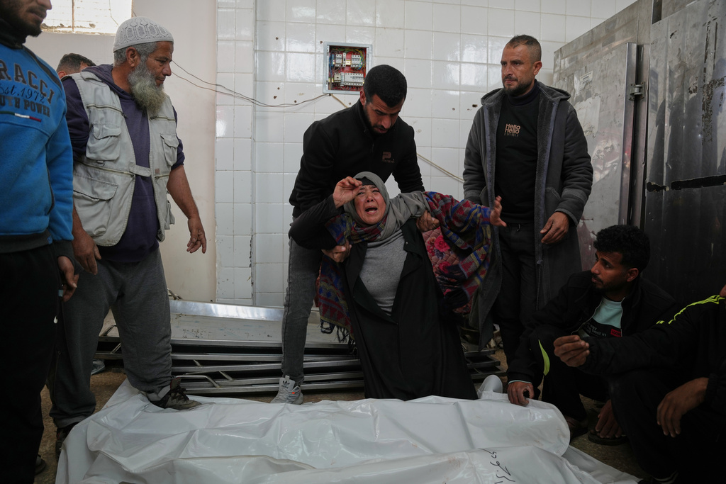 Najwa Al-Rajoudi mourns over the body of her nephew Moussa Al-Rajoudi before his funeral at Al-Aqsa Hospital in Deir al-Balah, central Gaza Strip, Wednesday, Jan. 21, 2026, after he was killed by Israeli fire. (AP Photo/Abdel Kareem Hana)