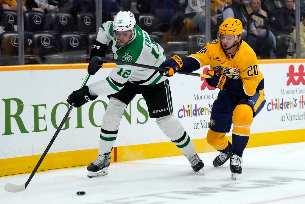 Nashville Predators defenseman Justin Barron (20) tries to slow down Dallas Stars center Radek Faksa (12) during the first period of an NHL hockey game Saturday, Nov. 8, 2025, in Nashville, Tenn. (AP Photo/Mark Humphrey)