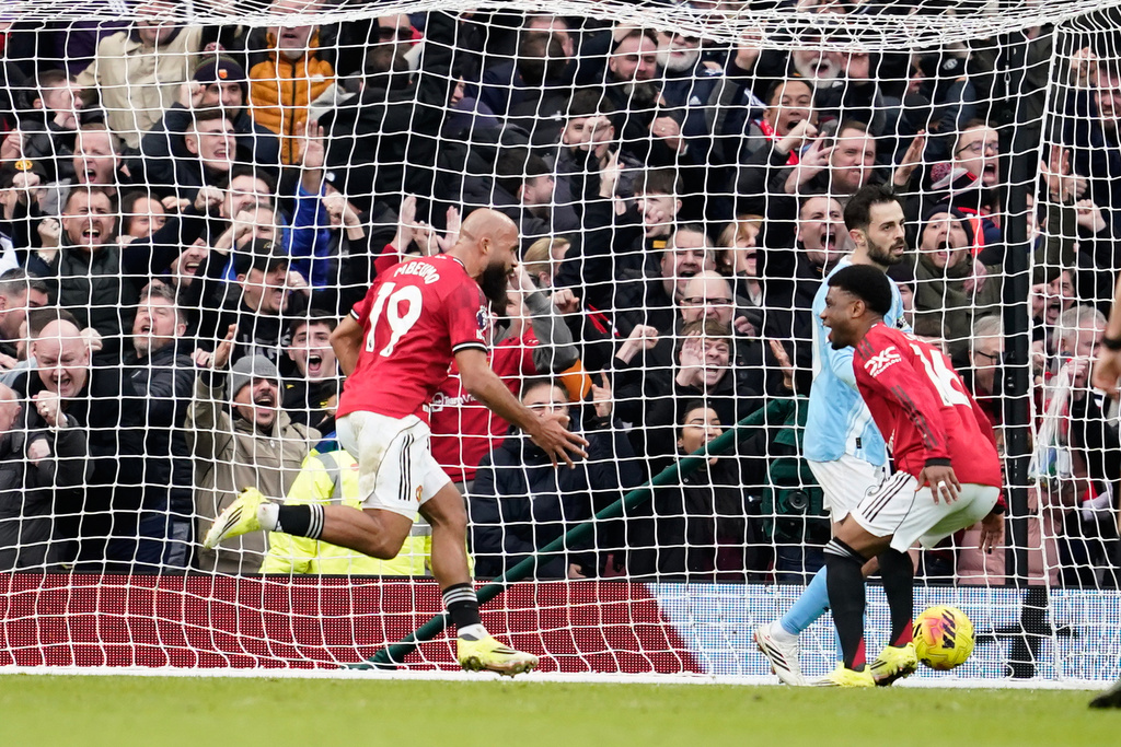Manchester United's Bryan Mbeumo, left, celebrates after scoring his side's opening goal during the English Premier League soccer match between Manchester United and Manchester City in Manchester, England, Saturday, Jan. 17, 2026. (AP Photo/Dave Thompson)