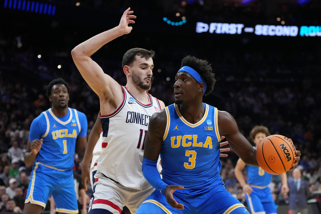 UCLA's Eric Dailey Jr., right, tries to get past UConn's Alex Karaban during the first half in the second round of the NCAA college basketball tournament, Sunday, March 22, 2026, in Philadelphia. (AP Photo/Matt Slocum)