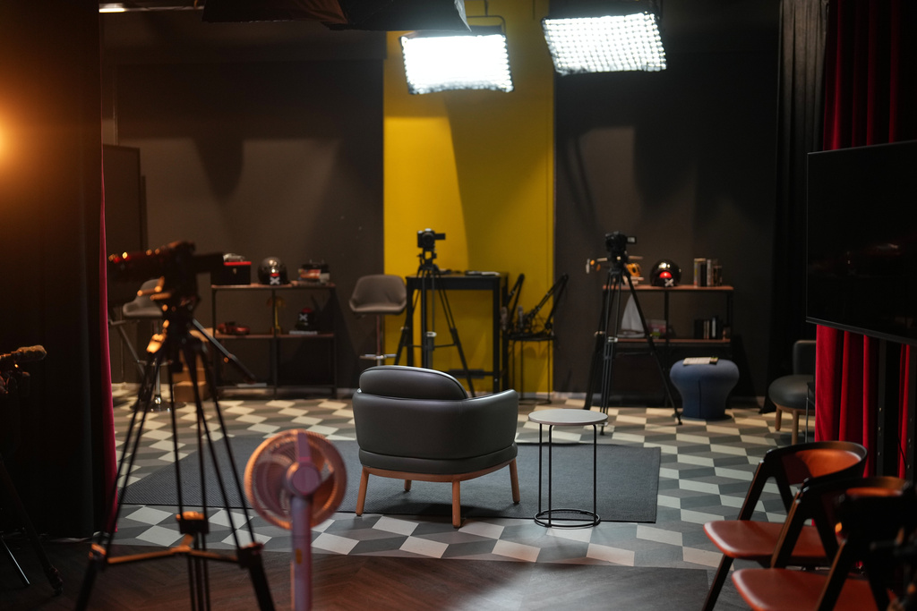 An empty chair takes center stage at a TV studio set where imprisoned Turkish journalist Fatih Altayli continues to deliver news on his YouTube show through letters read by his assistant, in Istanbul, Wednesday, Oct. 1, 2025. (AP Photo/Francisco Seco)
