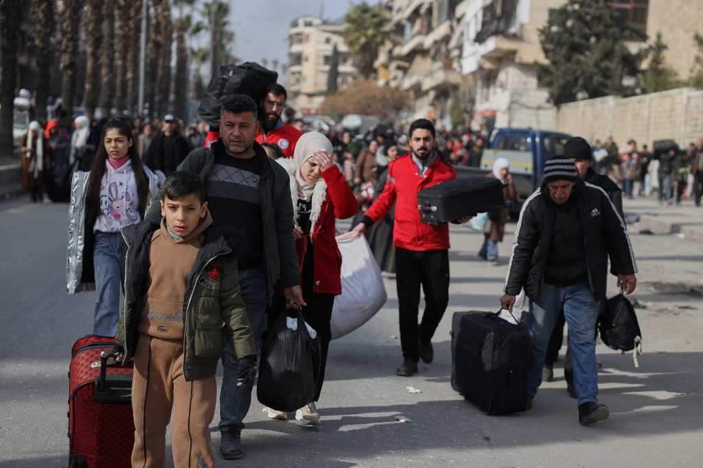 Residents flee the Sheikh Maqsoud and Achrafieh neighborhoods after clashes broke out on Tuesday between Syrian government forces and Kurdish fighters in a contested area of the northern city of Aleppo, Syria, Wednesday, Jan. 7, 2026. (AP Photo/Omar Albam)
