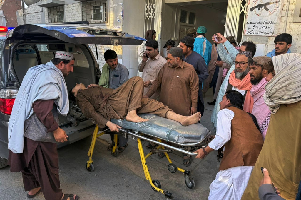 People bring a man, who was injured in the clashes between Pakistan and Afghan forces in border area, for medical treatment at a hospital in Chaman, a town on the Pakistan side of the border, Wednesday, Oct. 15, 2025. (AP Photo/H. Achakzai)