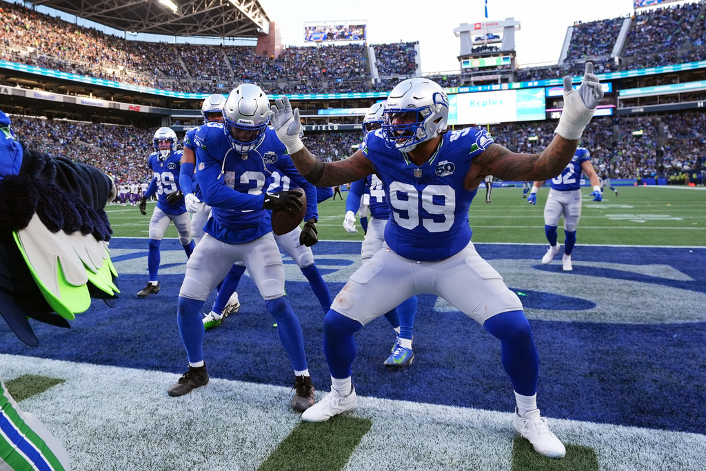 REMOVES ZACH CHARBONNET - Seattle Seahawks linebacker Ernest Jones IV (13) and defensive end Leonard Williams (99) celebrate after an interception by Jones during the second half of an NFL football game against the Minnesota Vikings on Sunday, Nov. 30, 2025, in Seattle. (AP Photo/ Lindsey Wasson)