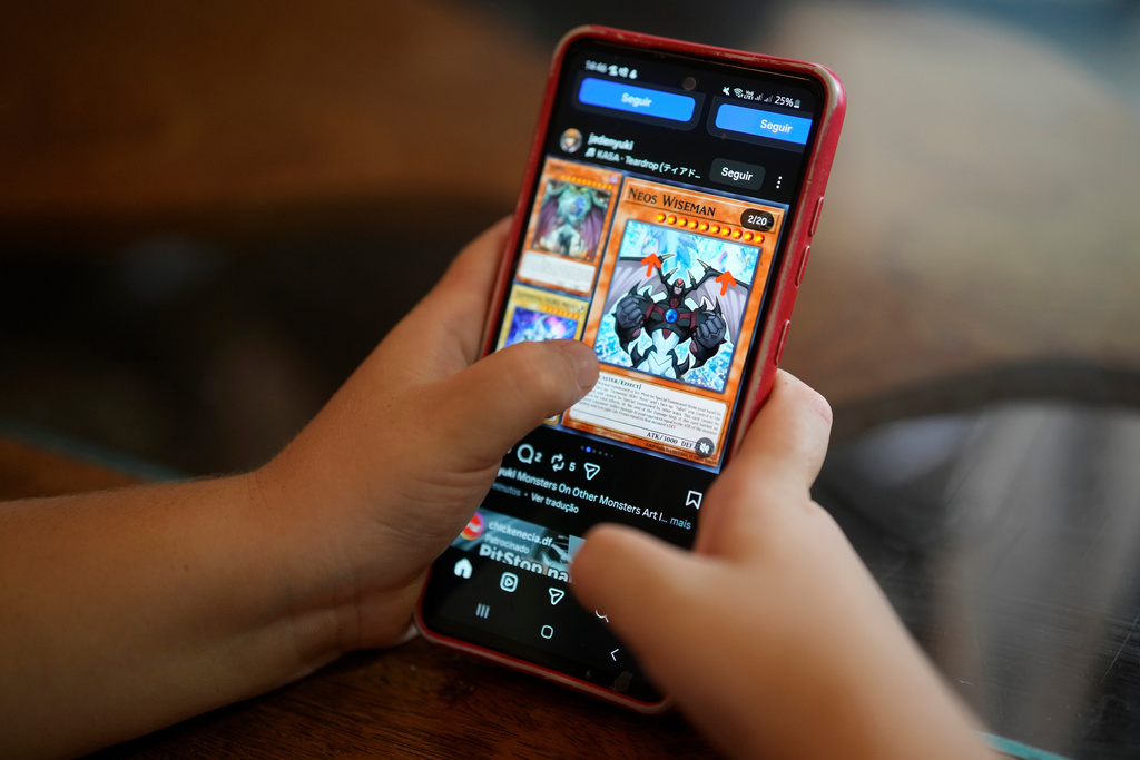 A boy uses a social media platform in Brasilia, Brazil, Thursday, March 19, 2026. A new law regulating children’s use of social media took effect this week, requiring users under 16 to link their accounts to a legal guardian. (AP Photo/Eraldo Peres)