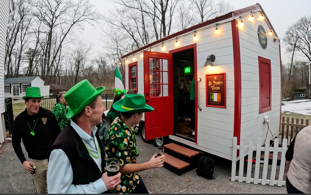 Revelers gather for an early St. Patrick's Day party in a rented tiny pub, Friday, March 13, 2026, in Andover, Mass. (AP Photo/Robert F. Bukaty)