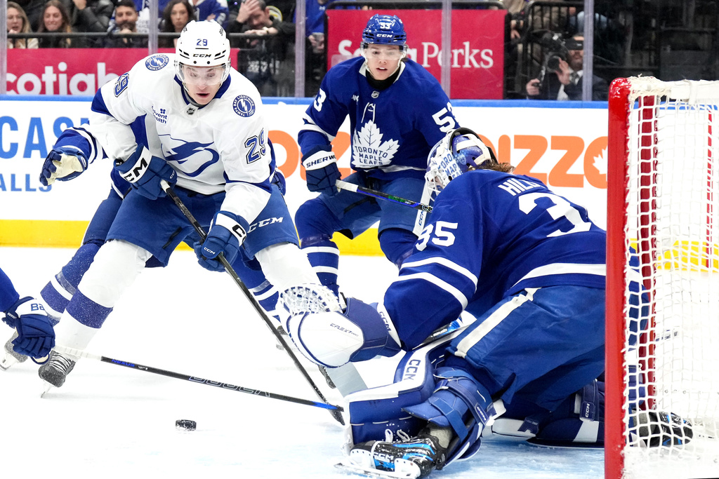 Tampa Bay Lightning right wing Pontus Holmberg, left, looks to shoot on Toronto Maple Leafs goaltender Dennis Hildeby, rigjht, during the first period of an NHL hockey game in Toronto, Monday, Dec. 8, 2025. (Chris Young/The Canadian Press via AP)