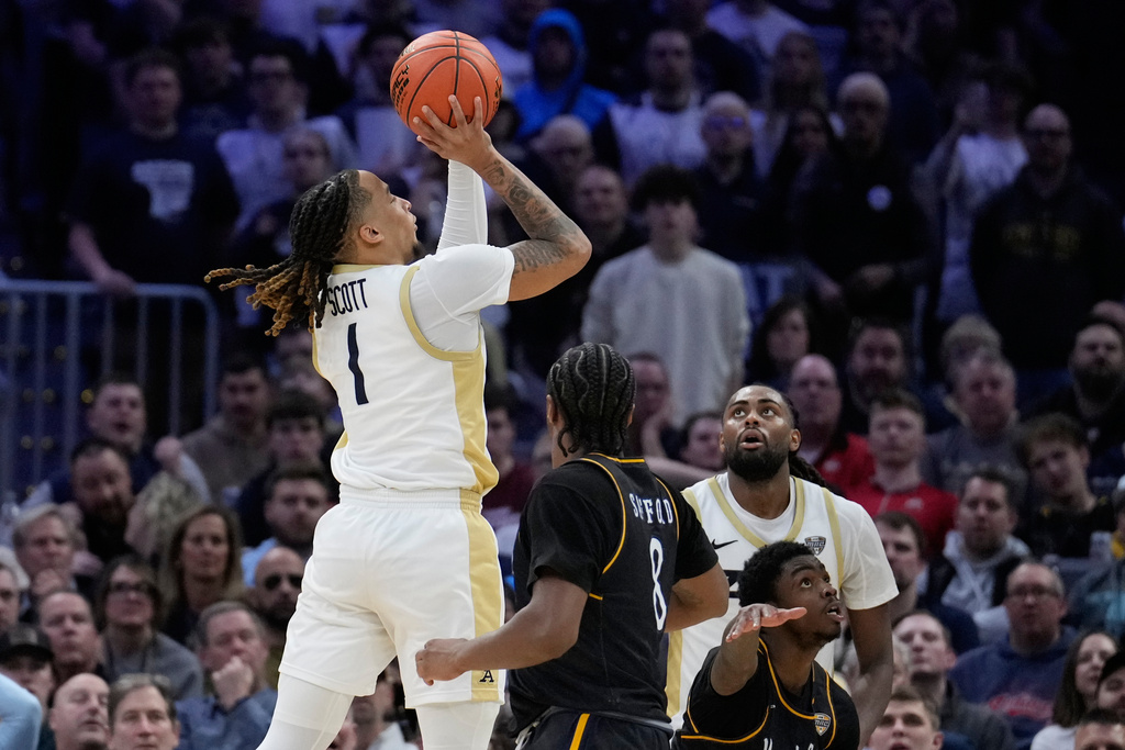 Akron guard Shammah Scott (1) shoots next to Kent State guard Morgan Safford (8) in the second half of a basketball game in the semifinals of the Mid-American Conference tournament, Friday, March 13, 2026, in Cleveland. (AP Photo/Sue Ogrocki)