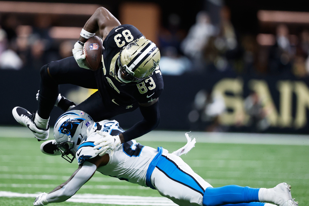 New Orleans Saints tight end Juwan Johnson (83) is tackled by Carolina Panthers safety Nick Scott (21) in the second half of an NFL football game, Sunday, Dec. 14, 2025, in New Orleans. (AP Photo/Butch Dill)
