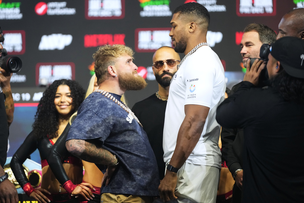 Jake Paul, left, and Anthony Joshua face off during a news conference promoting their upcoming heavyweight boxing match, Wednesday, Dec. 17, 2025, in Miami Beach, Fla. (AP Photo/Lynne Sladky)