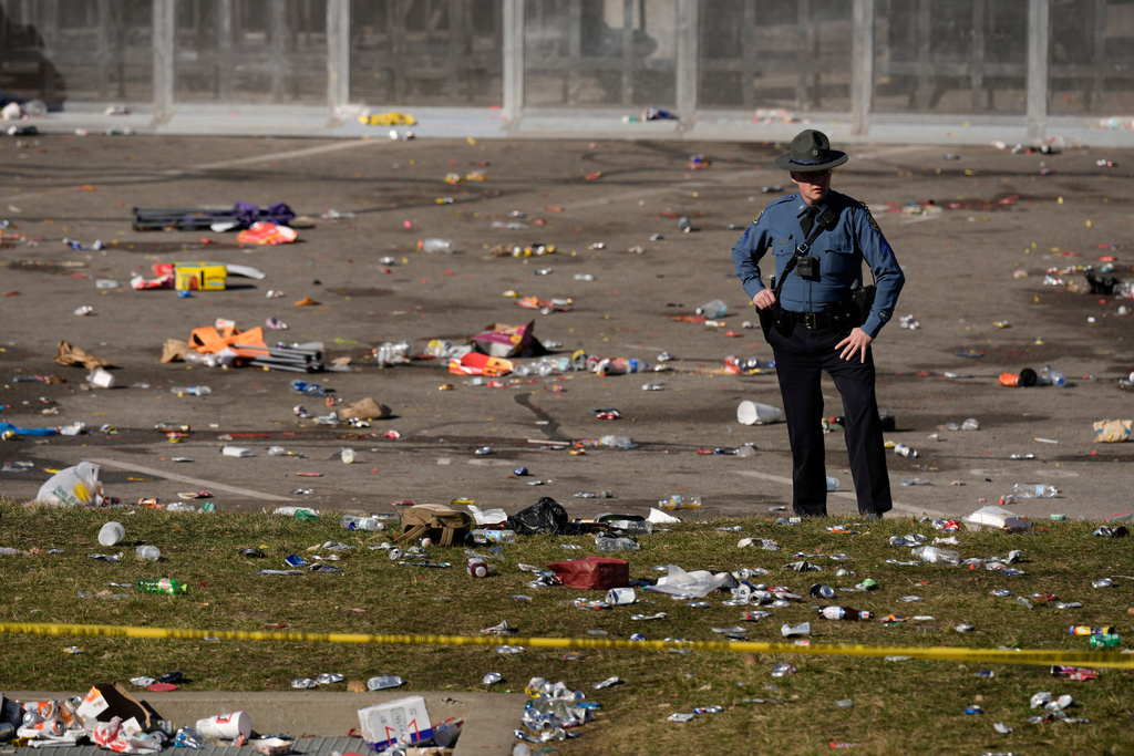 FILE - A law enforcement officer looks around the scene following a shooting at the Kansas City Chiefs NFL football Super Bowl celebration, in Kansas City, Mo., Feb. 14, 2024. (AP Photo/Charlie Riedel, File)