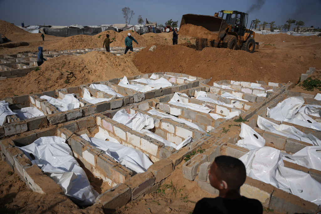 Bodies of unidentified Palestinians returned from Israel as part of the ceasefire deal are buried in Deir al-Balah, Gaza Strip, Friday, Feb. 13, 2026. (AP Photo/Abdel Kareem Hana)