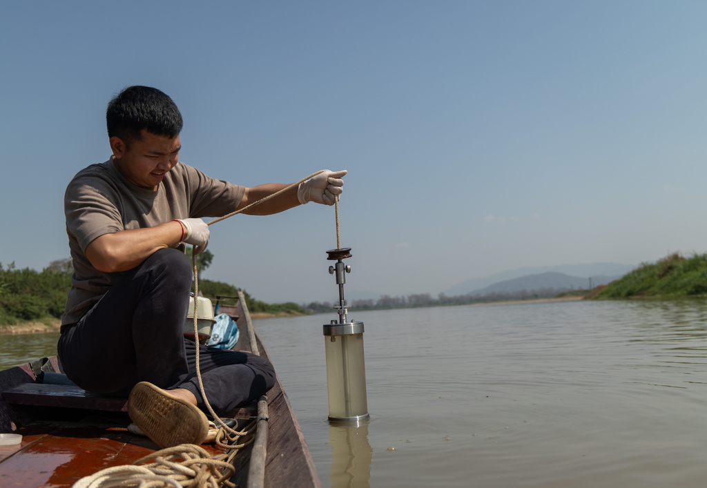 Researcher Khanasuan Kaeothip takes a water sample from the Kok River, in Chiang Saen, Thailand, on Feb. 17, 2026. (AP Photo/Anton L. Delgado)