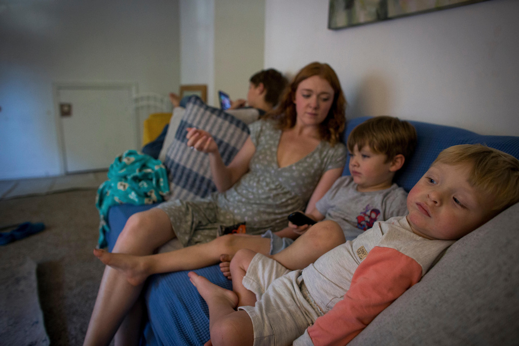 Taylor Moyer, center with her children Liam, from left, Colton, and Bradley at home, Sunday, Oct. 5, 2025, in Virginia Beach, Va. (AP Photo/John Clark)