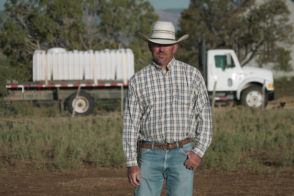 Lance Bray stands in front of a truck he purchased this spring for hauling stock water, July 17, 2026 in Redvale, Colo. (AP Photo/Brittany Peterson)