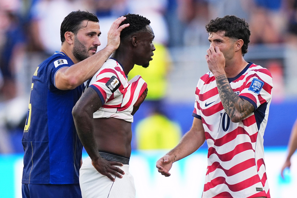 United States' Folarin Balogun (20) gets a pat on the head from Bosnia's Sead Kolasinac (5) as United States' Christian Pulisic (10) stands by after receiving a red card during the World Cup round of 32 soccer match between the United States and Bosnia in Santa Clara, Calif., near San Francisco, Wednesday, July 1, 2026. (AP Photo/Martin Meissner)
