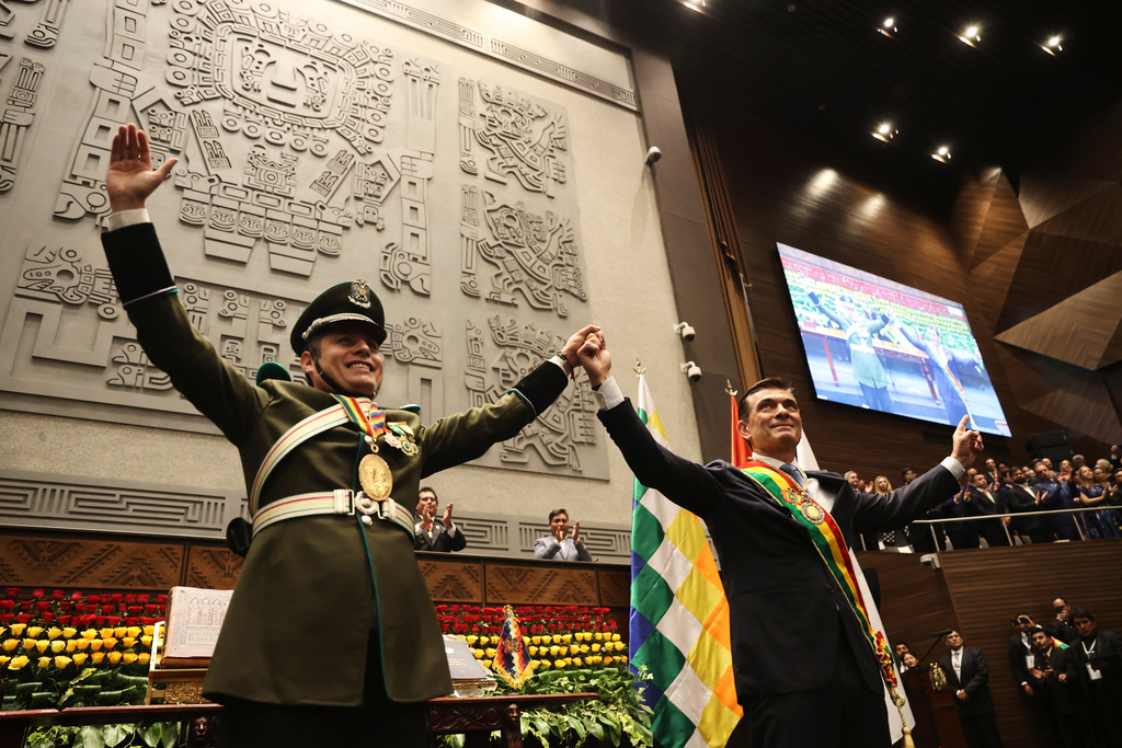 President Rodrigo Paz, right, and Vice President Edman Lara hold hands after the swearing-in ceremony in La Paz, Bolivia, Saturday, Nov. 8, 2025. (Luis Gandarillas/Pool Photo via AP)