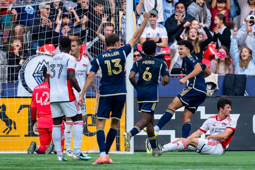 Vancouver Whitecaps' Rayan Elloumi, second from right, celebrates with teammate Ralph Priso (6) after scoring as San Jose Earthquakes' Daniel Munie, right, looks on during the first half of an MLS soccer match in Vancouver, British Columbia, Sunday, Oct. 5, 2025. (Ethan Cairns/The Canadian Press via AP)