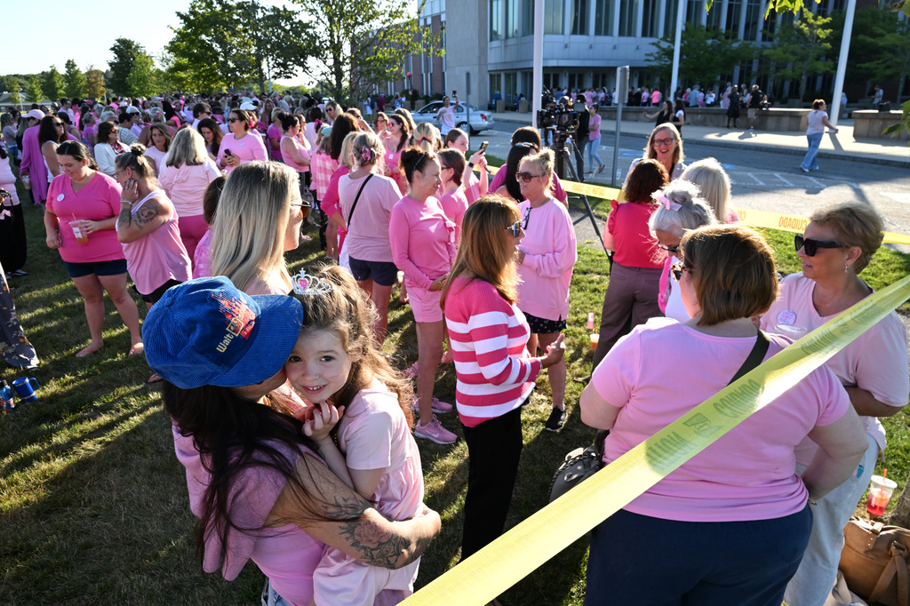 Kara Hurston holds her daughter Prinn, 4, as they join a demonstration in support of Lindsay Clancy outside Plymouth Superior Court, where Clancy is on trial in connection with the deaths of her three children, Thursday, Aug. 20, 2026, in Plymouth, Mass. (AP Photo/Josh Reynolds )