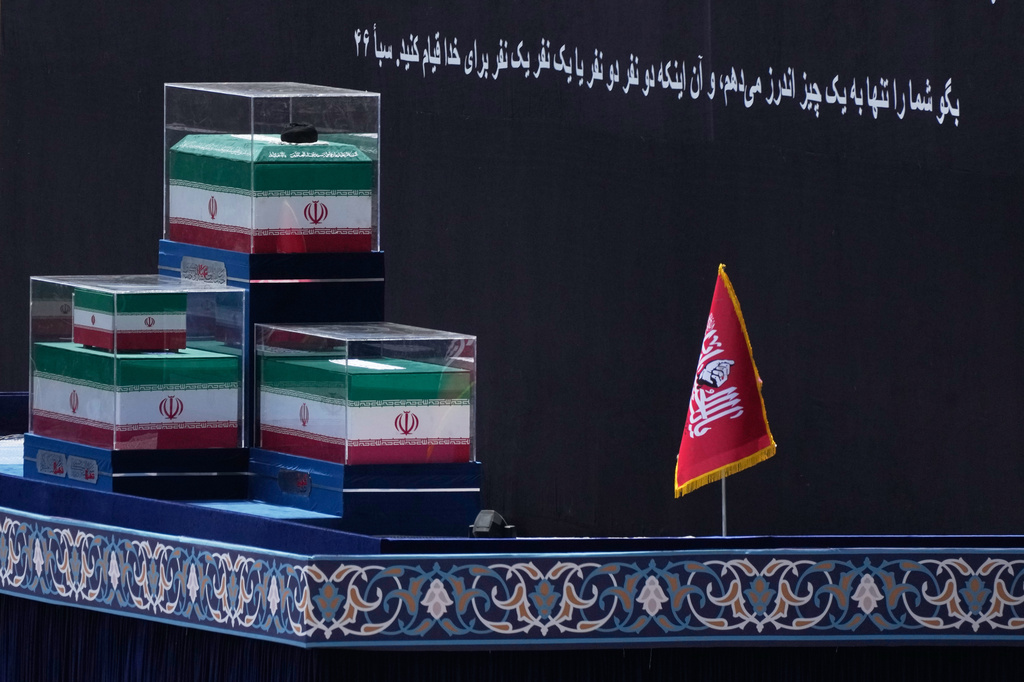 The coffins of the late Iranian Supreme Leader Ayatollah Ali Khamenei and members of his family are displayed on a platform before the start of the dayslong funeral ceremonies at the Imam Khomeini Mosalla Grand Mosque in Tehran, Iran, Saturday, July 4, 2026. A Quran verse in Persian on the backdrop reads, "Say, 'I only advise you of one thing: that you stand for Allah, in pairs or individually.'" (AP Photo/Vahid Salemi)