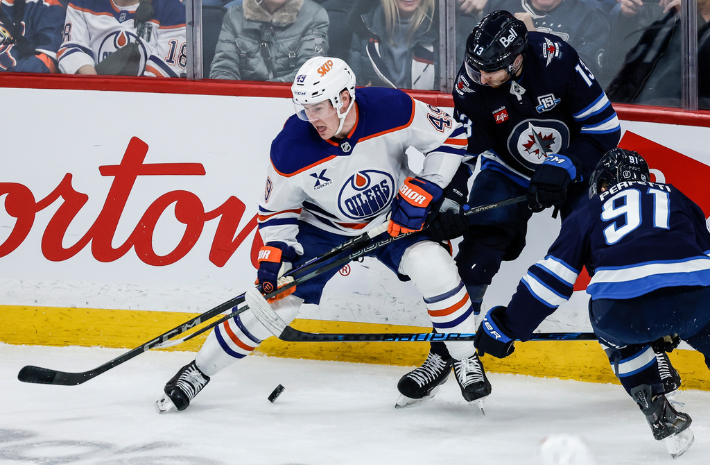 Edmonton Oilers' Ty Emberson (49) defends against Winnipeg Jets' Gabriel Vilardi (13) and Cole Perfetti (91) during second period NHL action in Winnipeg, Manitoba, Thursday, Jan. 8, 2026. (John Woods/The Canadian Press via AP)