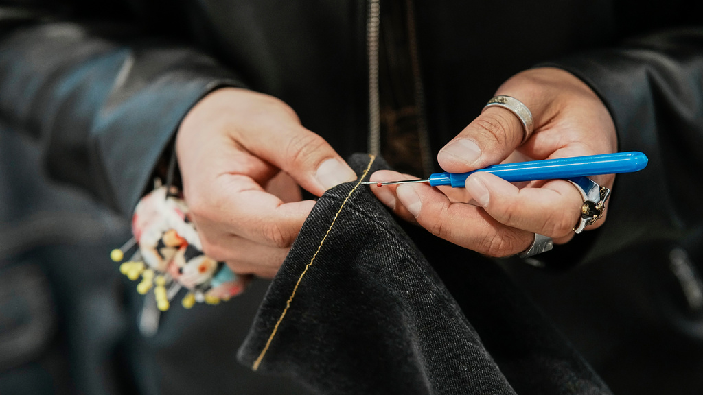 Tailor Marco Lema, 35, of Ecuador, works on a denim alteration at Nordstrom Manhattan flagship in New York, Monday, March 23, 2026. (AP Photo/Eduardo Munoz Alvarez) CORRECTION: Corrects to Nordstrom Manhattan flagship, not Nordstrom headquarters