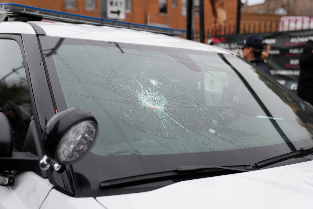 The wind shield of a Chicago police vehicle is smashed as people protesting the actions of federal immigration agents in Little Village clash with Chicago police officers Saturday, Nov. 8, 2025, in Chicago. (AP Photo/Erin Hooley)