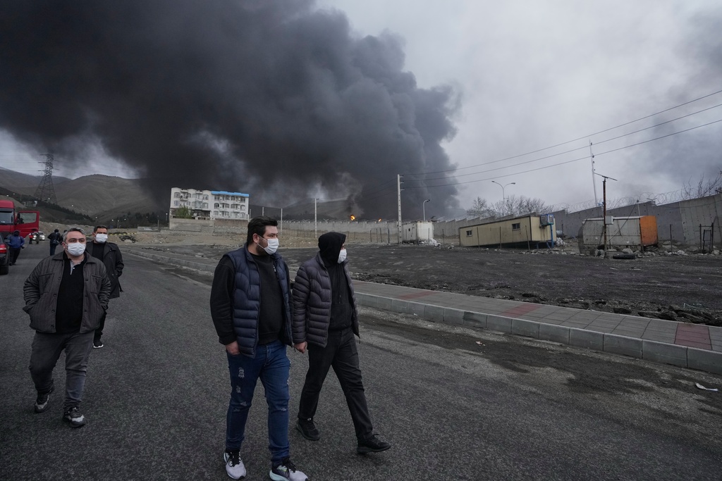 FILE - A thick plume of smoke rises March 8, 2026, from an oil storage facility struck overnight in Tehran, Iran. (AP Photo/Vahid Salemi, File)