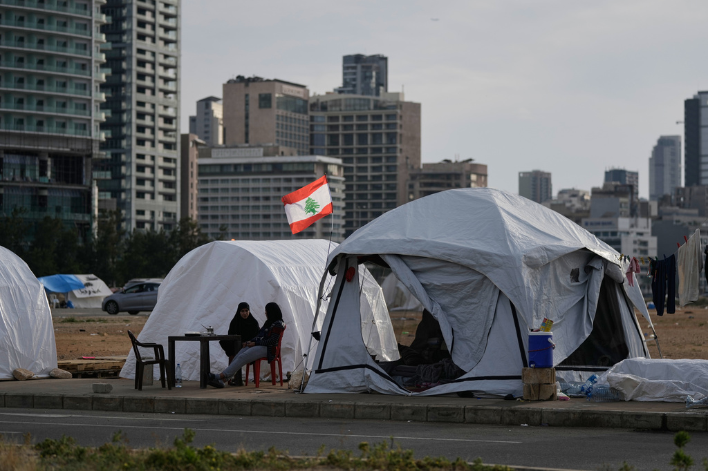 Displaced people who fled Israeli strikes in southern Lebanon sit outside shelter tents in Beirut, April 24, 2026. (AP Photo/Bilal Hussein)