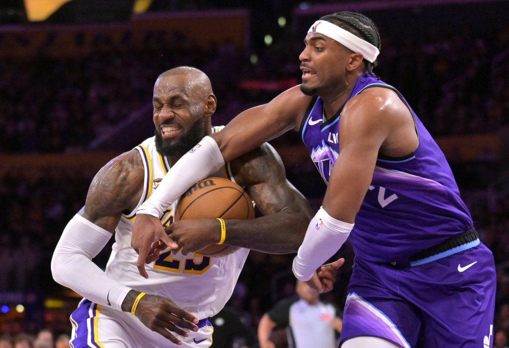 Los Angeles Lakers forward LeBron James, left, is fouled by Utah Jazz forward Blake Hinson (2) as he drives to the basket during the first half of an NBA basketball game Sunday, April 12, 2026, in Los Angeles. (AP Photo/Jayne Kamin-Oncea)