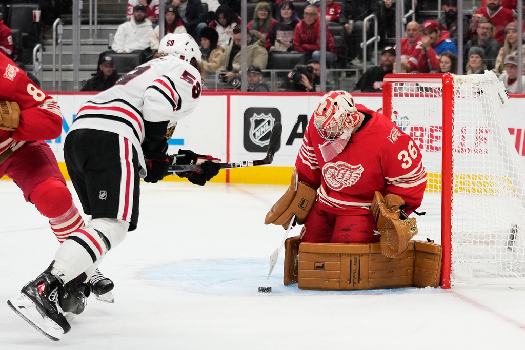 Chicago Blackhawks left wing Tyler Bertuzzi (59) against Detroit Red Wings goaltender John Gibson, right, during the third period of an NHL hockey game Sunday, Nov. 9, 2025, in Detroit. (AP Photo/Ryan Sun)