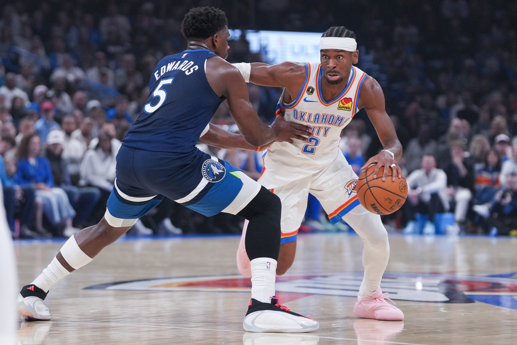 Oklahoma City Thunder guard Shai Gilgeous-Alexander, right, pushes past Minnesota Timberwolves guard Anthony Edwards (5) during the first half of an NBA basketball game, Sunday, March 15, 2026, in Oklahoma City. (AP Photo/Kyle Phillips)