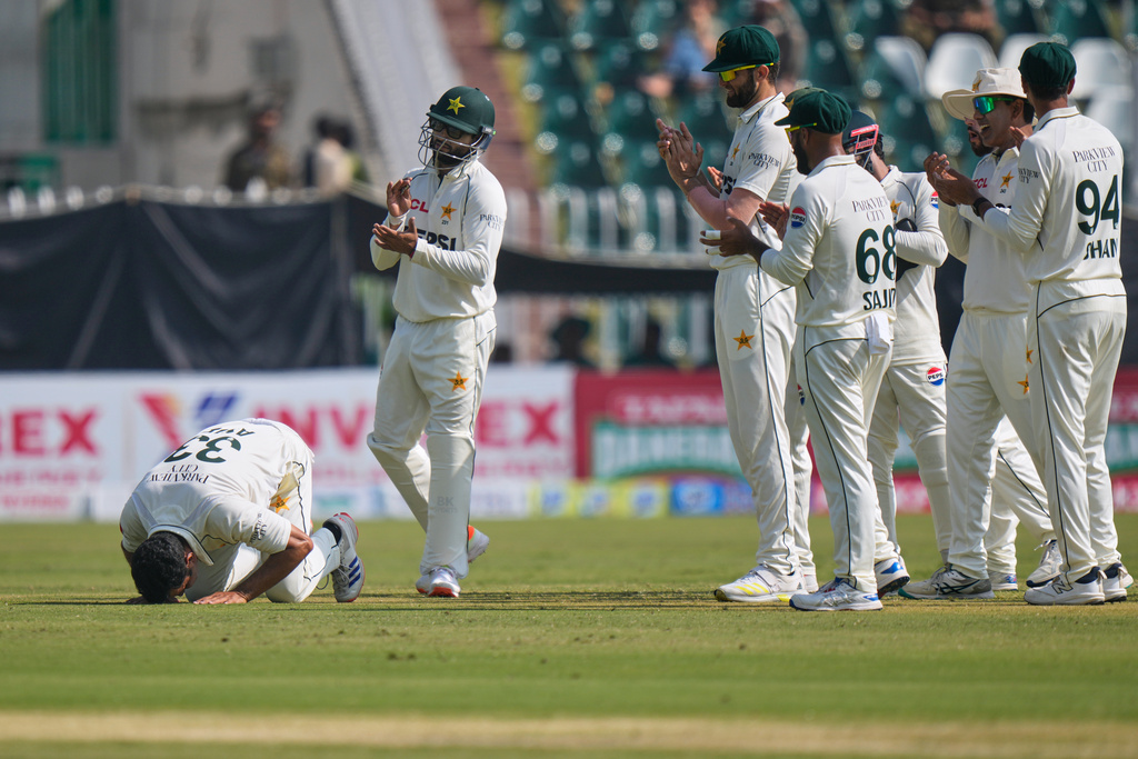 Pakistan's Asif Afridi, left, performs Sajdah, a prayer bow in gratitude to God, as teammates clapping after he took his fifty wicket to dismiss South Africa's Simon Harmer during the third day of the second test cricket match between Pakistan and South Africa, in Rawalpindi, Pakistan, Wednesday, Oct. 22, 2025. (AP Photo/Anjum Naveed)