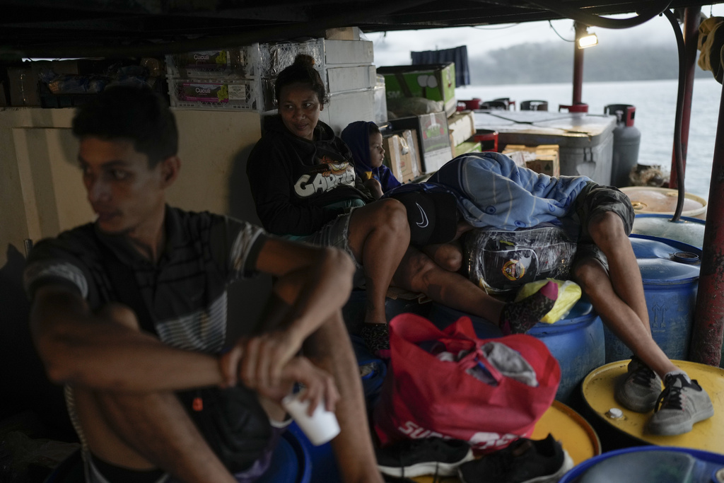 Venezuelan migrants Mariela Gomez, her two sons, and partner Abraham Castro return home on a cargo vessel on Panama's Pacific coast, Thursday, Sept. 18, 2025. The family is returning south after being detained by U.S. authorities in Texas and sent to southern Mexico. (AP Photo/Matias Delacroix)