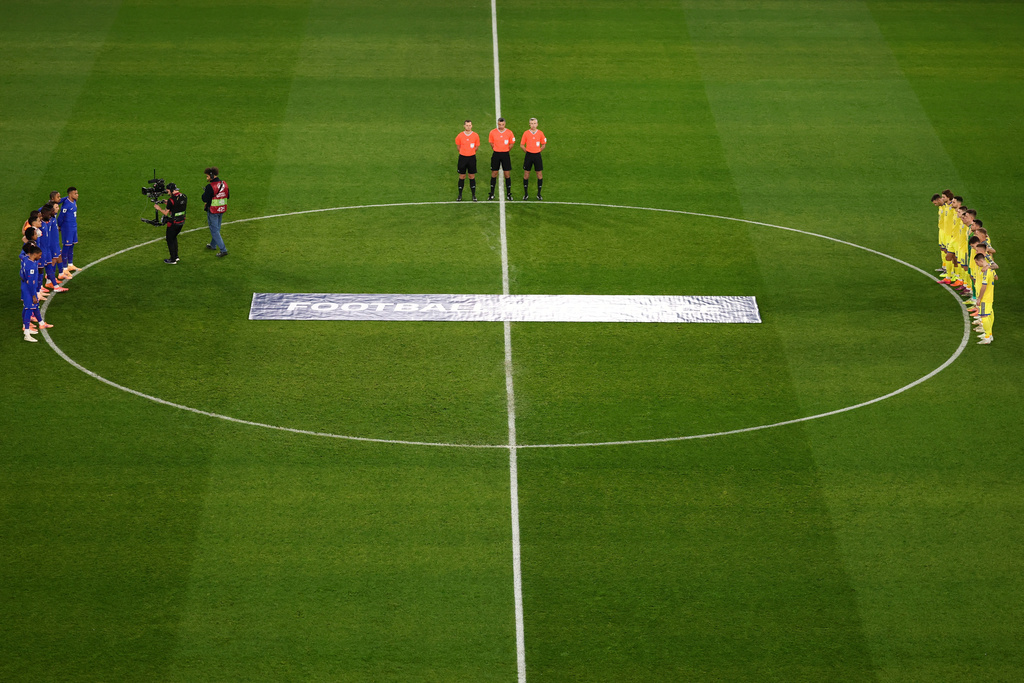 Ukrainian, right, and French players observe a minute of silence in tribute to the victims of the Nov.13, 2015 Paris attacks, ahead of the 2026 World Cup qualifiers Europe zone group D football match between France and Ukraine at the Parc des Princes stadium, Thursday, Nov. 13, 2025 in Paris. ( Franck Fife, Pool photo via AP)