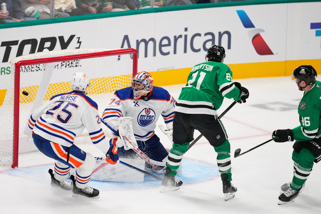Edmonton Oilers' Darnell Nurse (25), goaltender Stuart Skinner (74) and Dallas Stars' Jason Robertson (21) look on as Mikko Rantanen (96) scores in the third period of an NHL hockey game Tuesday, Nov. 4, 2025, in Dallas. (AP Photo/Tony Gutierrez)