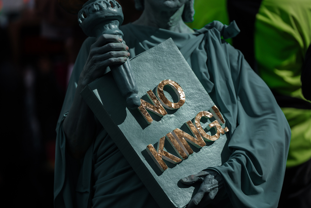 A Protester dressed in a Statue of Liberty costume holds a "No Kings" sign during a "No Kings" protest Saturday, Oct. 18, 2025, in New York. (AP Photo/Olga Fedorova)
