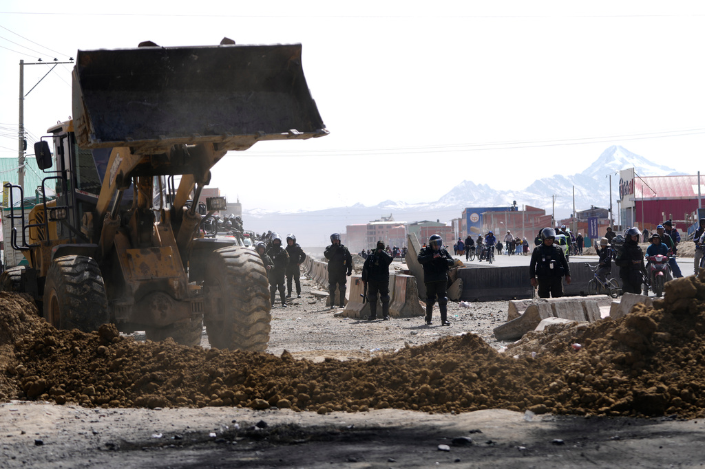 Police clear a highway blocked by protesters after President Rodrigo Paz declared a state of emergency in El Alto, Bolivia, Saturday, June 20, 2026. (AP Photo/Juan Karita)