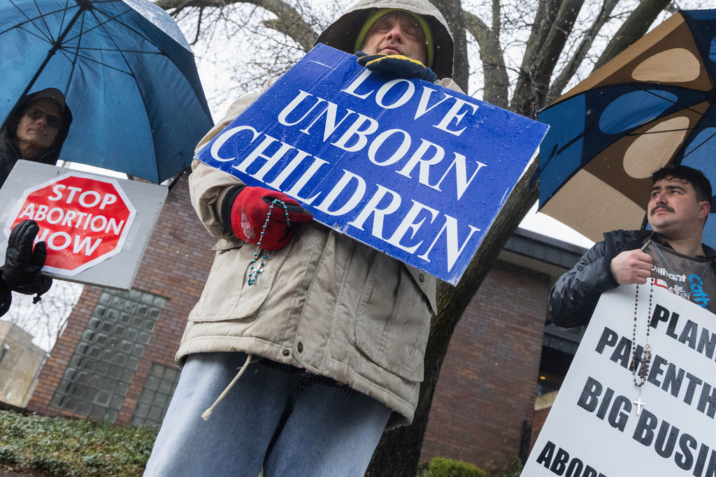 FILE - Grand Rapids anti-abortion activist Jim Albright, center, leads fellow activists Robert "Doc" Kovaly, left, and Miguel Jomarron Fernandez, right, to pray the Rosary at Planned Parenthood, April 2, 2025, in Grand Rapids, Mich. (Arthur H. Trickett-Wile/MLive.com/The Grand Rapids Press via AP, File)