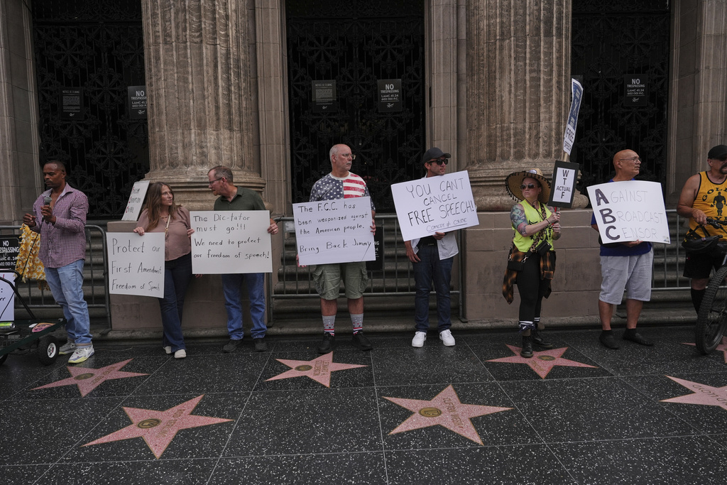 Demonstrators hold signs outside El Capitan Entertainment Centre, where the late-night show "Jimmy Kimmel Live!" is staged, Thursday, Sept. 18, 2025, in Los Angeles. (AP Photo/Jae C. Hong)