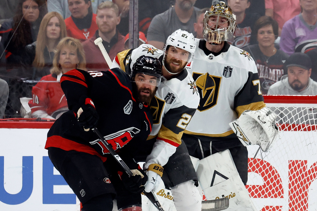 Carolina Hurricanes' Jordan Martinook (48) battles for position with Vegas Golden Knights' Shea Theodore (27) in front of goaltender Carter Hart (79) during the first period in Game 2 of the NHL hockey Stanley Cup Final series in Raleigh, N.C., Thursday, June 4, 2026. (AP Photo/Karl DeBlaker)
