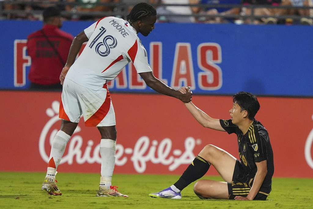 Los Angeles FC forward Heung Min Son, right, gets a hand up from FC Dallas defender Shaq Moore (18) during the second half of an MLS soccer match in Frisco, Texas, Saturday, Aug. 23, 2025. (AP Photo/LM Otero)