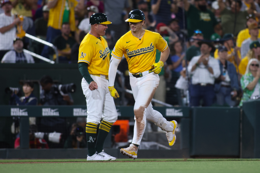 Athletics' Tyler Soderstrom, right, celebrates with third base coach Bobby Crosby, left, after hitting a solo home run during the sixth inning of a baseball game against the New York Yankees, Saturday, May 30, 2026, in West Sacramento, Calif. (AP Photo/Scott Marshall)