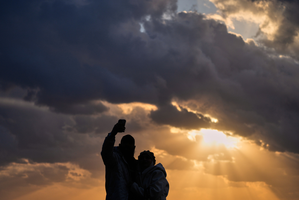 A couple takes a selfie as the last sunset of 2025 is seen over the Mediterranean Sea in Beirut, Lebanon, Wednesday, Dec. 31, 2025. (AP Photo/Hassan Ammar)