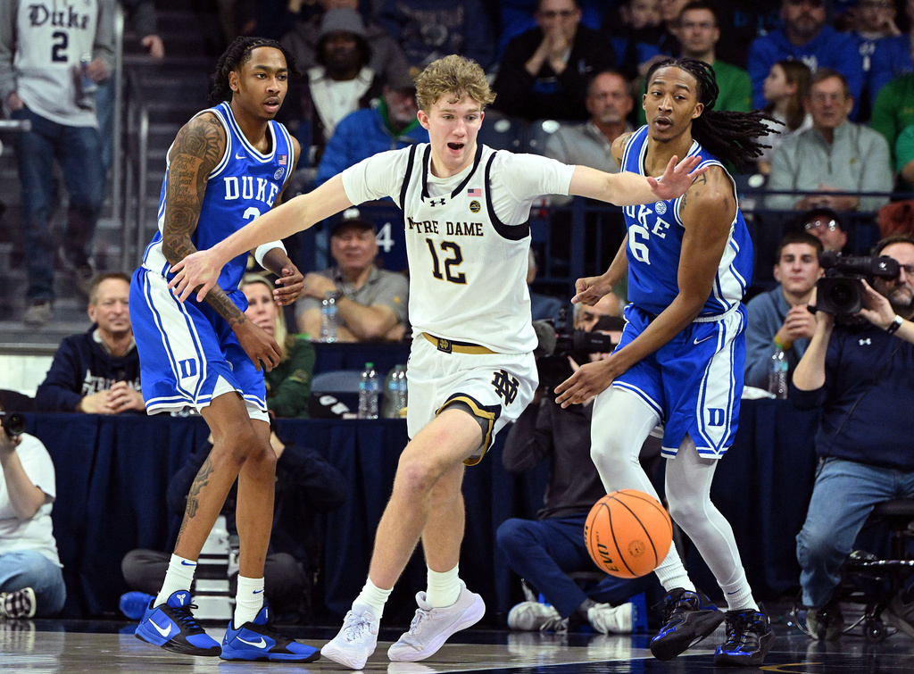 Notre Dame forward Garrett Sundra (12) looks at a loose ball in front of Duke guard Isaiah Evans and forward Maliq Brown (6) during the second half of an NCAA basketball game, Tuesday, Feb. 24, 2026, in South Bend, Ind. (AP Photo/Marc Lebryk)