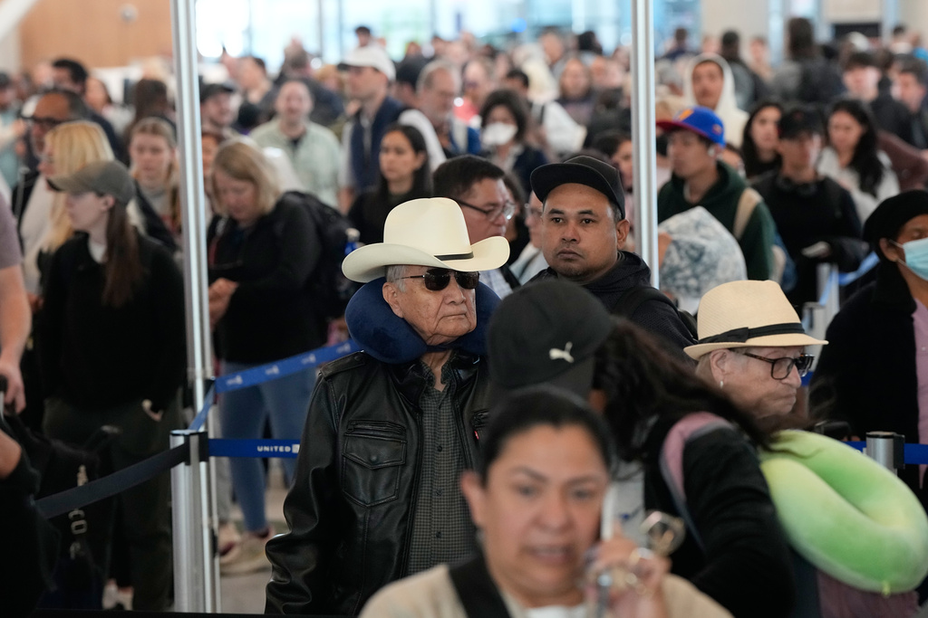 Passengers wait in a security checkpoint line at George Bush Intercontinental Airport Thursday, March 19, 2026, in Houston. (AP Photo/David J. Phillip)