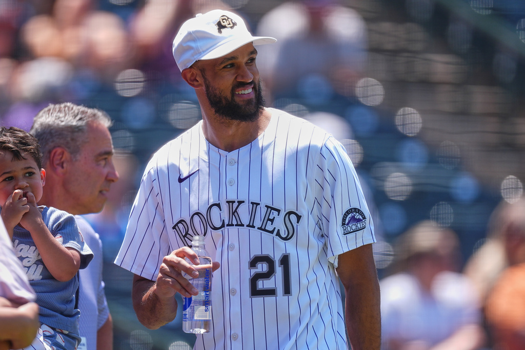 Boston Celtic guard Derrick White looks on after throwing out the ceremonial first pitch before the Colorado Rockies host the San Francisco Giants in the first inning of a baseball game Sunday, July 5, 2026, in Denver. (AP Photo/David Zalubowski)