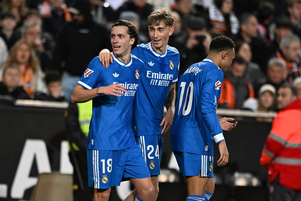 Real Madrid's Alvaro Carreras, left, celebrates with Dean Huijsen, centre and Kylian Mbappe after scoring the opening goal during the Spanish La Liga soccer match between Valencia and Real Madrid in Valencia, Spain, Sunday, Feb. 8, 2026. (AP Photo/Francisco Macia)