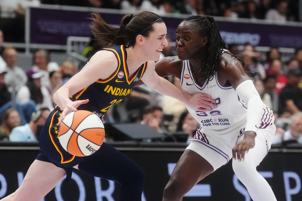 Indiana Fever's Caitlin Clark (22) drives as Toronto Tempo's Ornella Bankole (33) defends during first half WNBA basketball action in Toronto on Friday, Sept. 18, 2026. (Nathan Denette/The Canadian Press via AP)